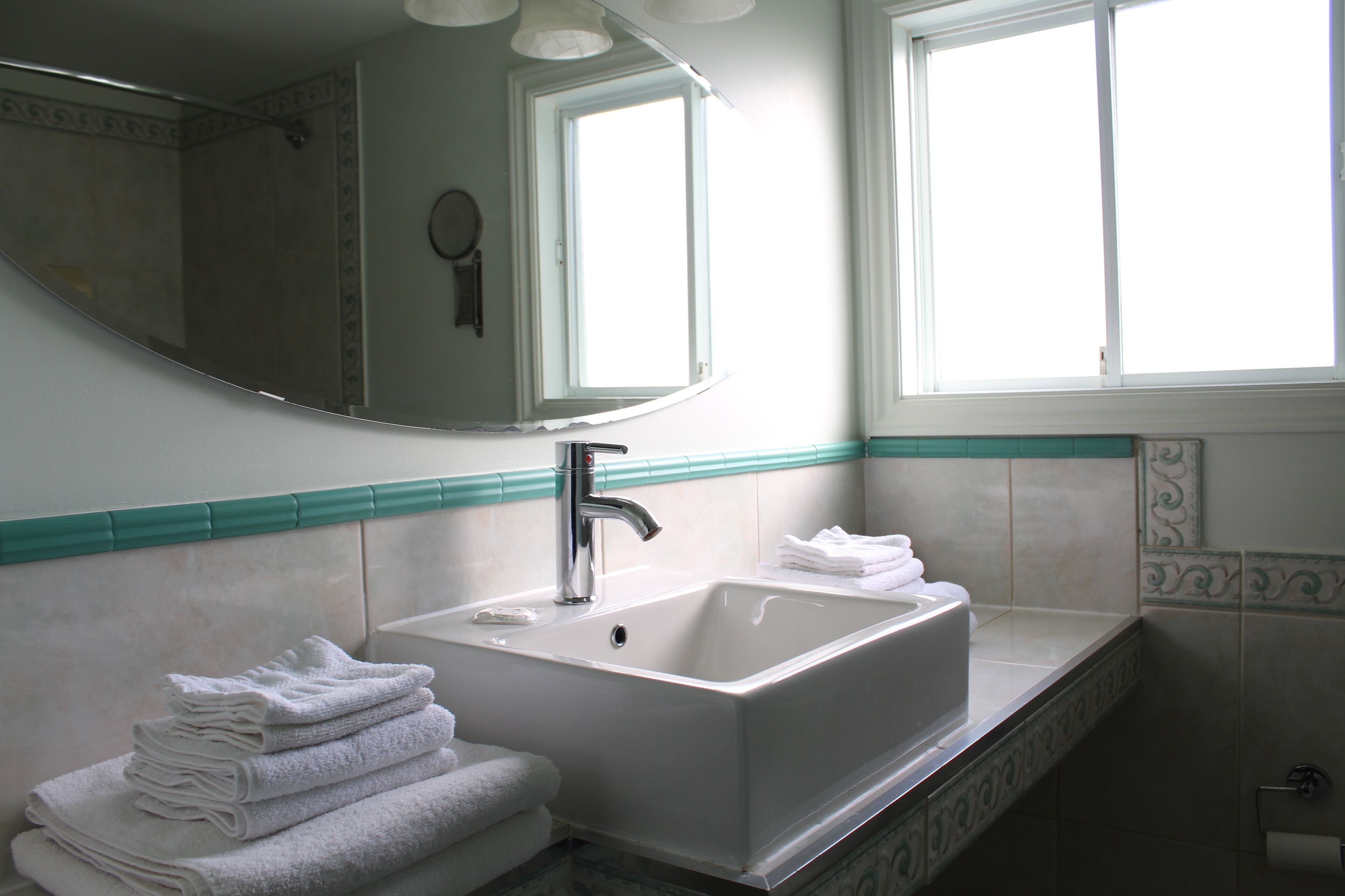 Ein Badezimmer mit Waschbecken, Spiegel und Fenster.