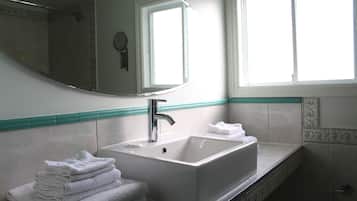 Ein Badezimmer mit Waschbecken, Spiegel und Fenster.