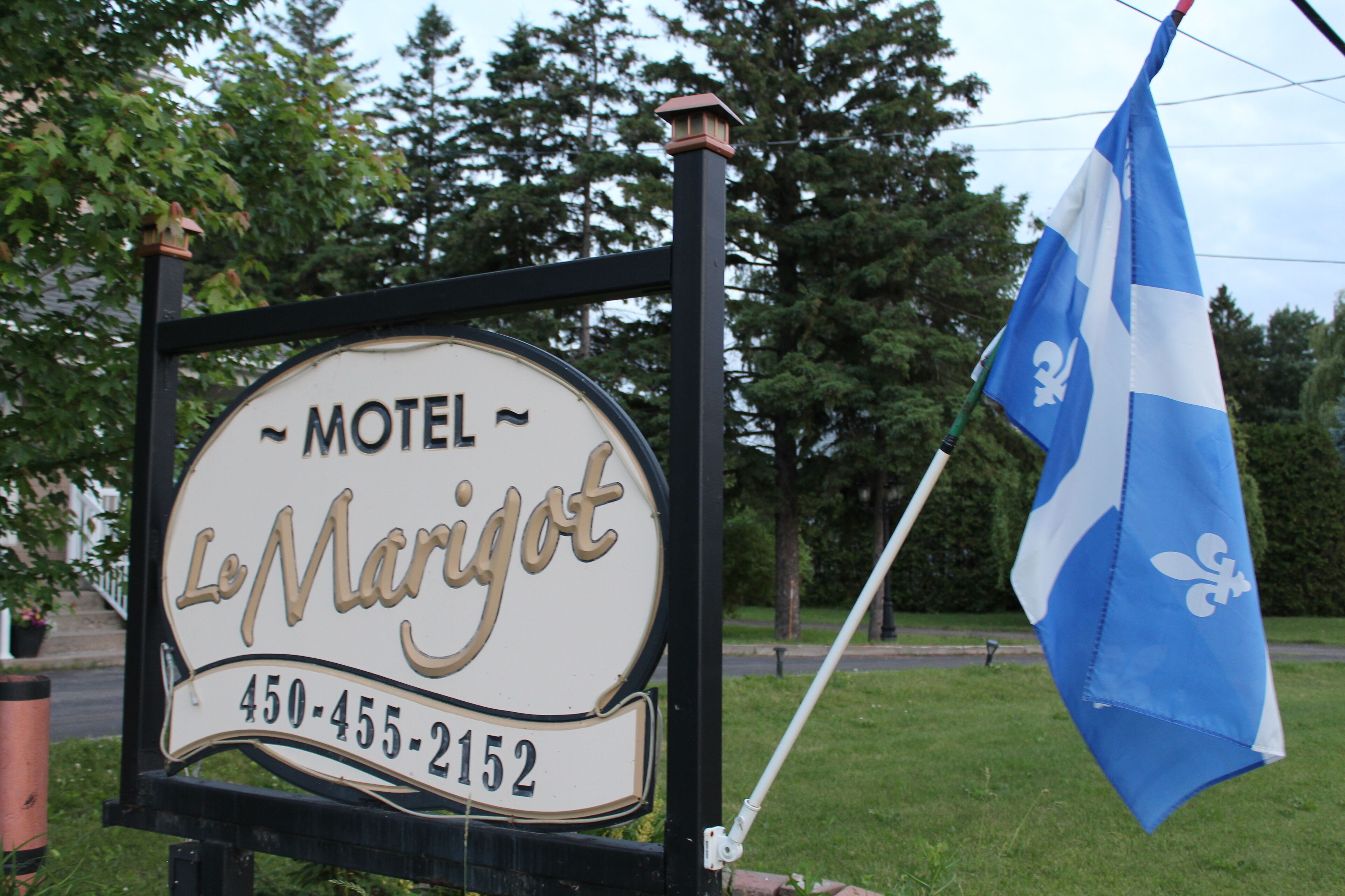 A motel sign with the name 'Le Marigot' and a phone number.
