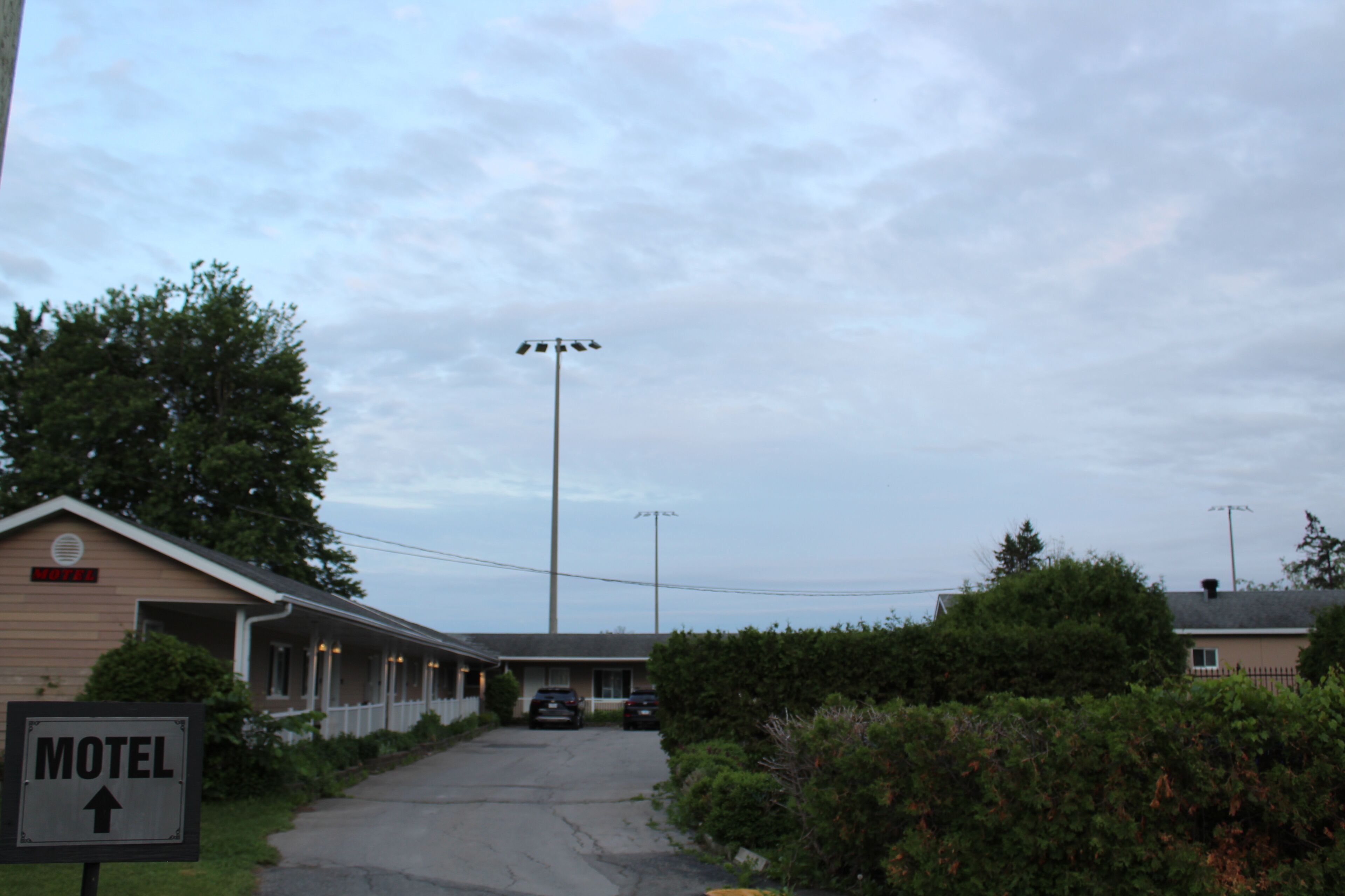 A motel with a sign indicating the direction to the rooms.