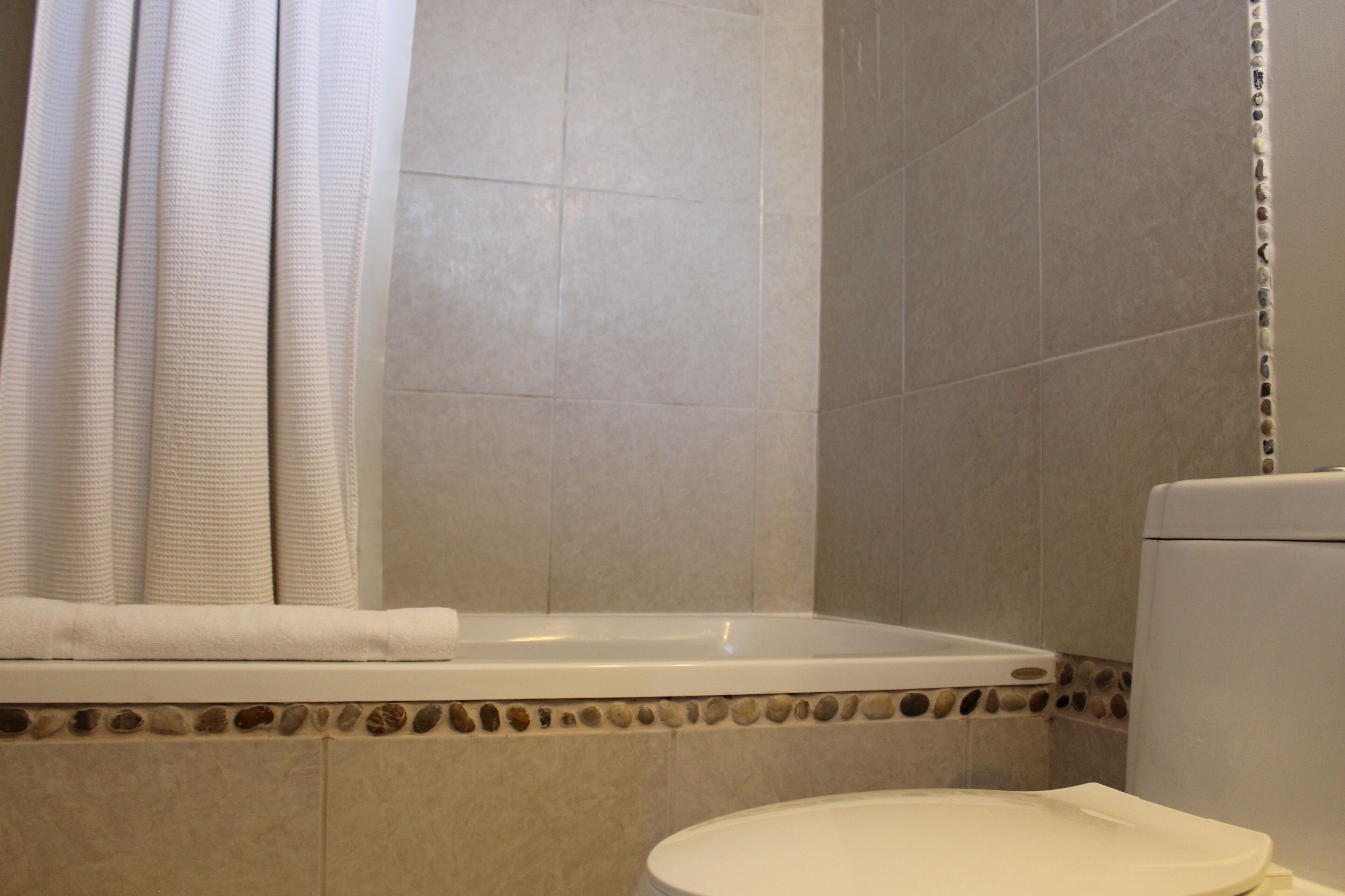 Bañera con ducha, toallas