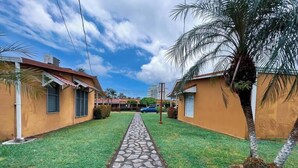 A pathway leading to a row of single-story buildings with a stone walkway.