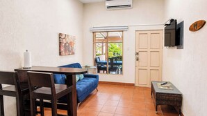 A compact living space with a dining table, blue sofa, and a small side table.