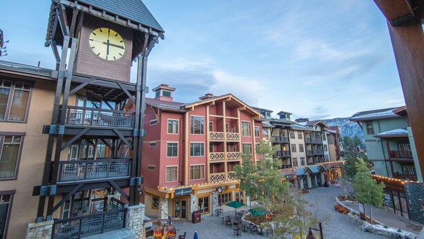 A multi-story building with a prominent clock tower, balconies, and a ground-level café area. - Grand Sierra Lodge: Walk to Village Gondola & Ski Back Trail (Mammoth Lakes)