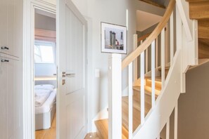 Ein Schlafzimmer mit einem Bett, einem Kleiderschrank und einer Tür zu einer Treppe.