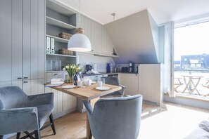 Una cocina moderna con una isla de madera, sillas grises y una lámpara colgante.