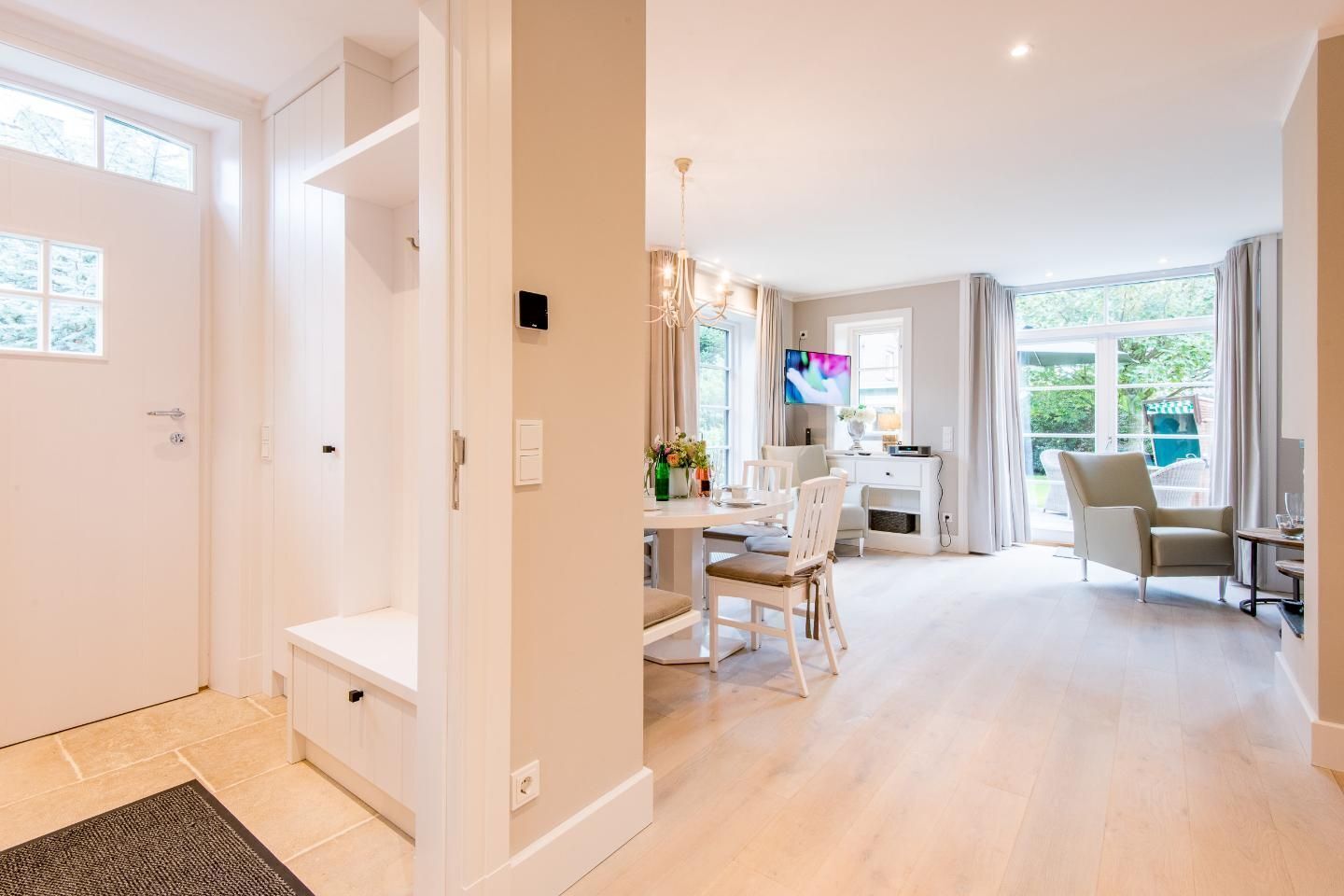 A modern, well-lit room with a dining area, a television, and a comfortable seating arrangement.