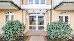 A building with a central entrance, two symmetrical side windows, and a brick pathway leading to the entrance.