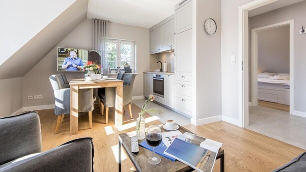 Un appartement moderne comprenant un coin repas, une cuisine et une chambre.