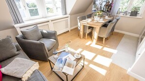 Un appartement moderne de style « loft », comprenant un coin repas, un espace salon confortable et une vue sur l’extérieur.