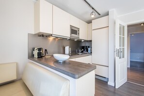 A modern kitchen with a large island, built-in appliances, and a minimalist design. - House Nordmarkgarten, Whg. 7 - House Nordmarkgarten (Sylt)