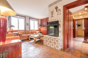Un salon chaleureux avec une cheminée, des carreaux décorés et des meubles en bois.