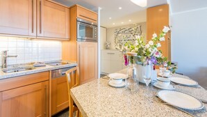 Een moderne keuken met houten kastjes, roestvrijstalen apparatuur en een granieten aanrecht.