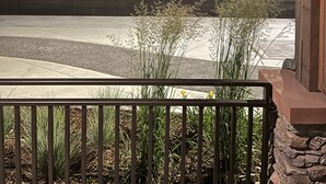 A porch with a view of a street and trees at dusk. - Rooms at Riveredge (Golden)