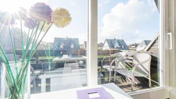 A room with a large window, a white table, and a purple book.