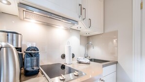 Une cuisine moderne équipée d’appareils électroménagers en acier inoxydable, d’un évier et d’un plan de travail.