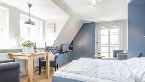 Een moderne slaapkamer met een groot bed, een bureau, een stoel en een televisie.