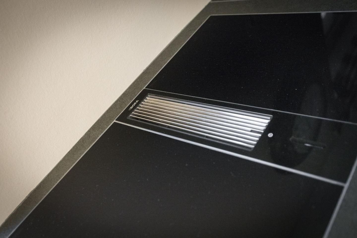 A black and white tiled floor with a vent in the center.