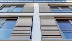 A modern building with large windows and horizontal wooden slats on the facade.