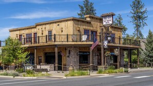 Un edificio de madera con un porche, banderas estadounidenses y un letrero para el Ski Inn Tap House Hotel.
