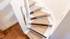 Una escalera de caracol con escalones de madera y paredes blancas.