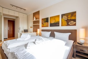 Una camera d'albergo con un letto grande, una scrivania e un armadio.