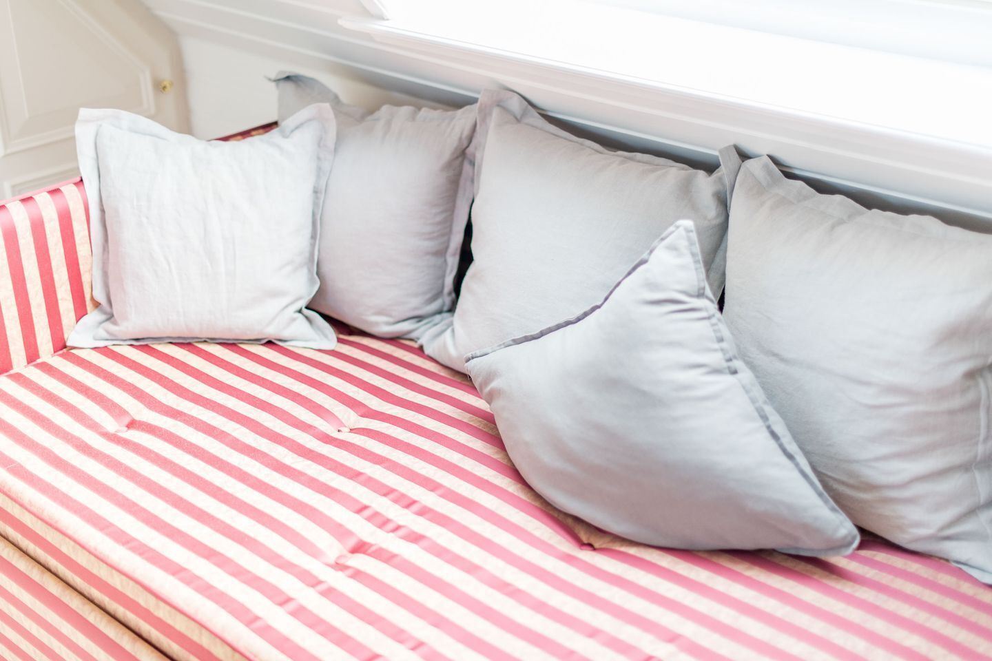 A bed with striped bedding and pillows.