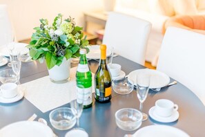 A dining table set with white plates, clear glasses, and a floral centerpiece. - Ostertresker 54, island oasis (Sylt-Ost)
