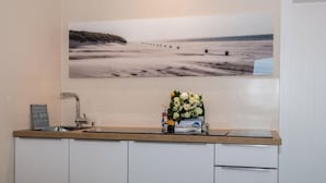 A kitchen with a wooden countertop, a sink, and a wall-mounted picture of a beach. - House Doktor-Ross-Straße 25, Whg. 19 Wunderkammer (Sylt)