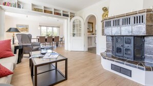 A spacious living room with a fireplace, a dining area, and a library. - Country house Tinnumburg, Germany (Sylt-Ost)
