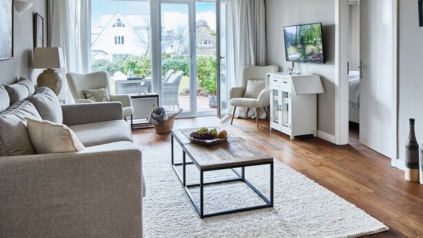 A modern living room with a sofa set, a coffee table, and a television. - Welcome to TECHTS - TECHTs Apartmenthaus (Timmendorfer Strand)