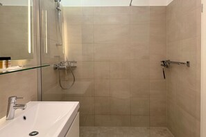 A modern bathroom with a shower, a sink, and a glass shelf. - "Meerzeit" maisonette apartment - stylish living at Timmendorfer Platz - TECHTs (Timmendorfer Strand)