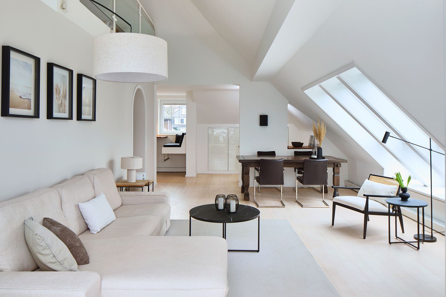 Ein geräumiger Lofts mit hoher Decke, einem Essbereich und einer gemütlichen Sitzecke mit Sofa und Couchtisch.
