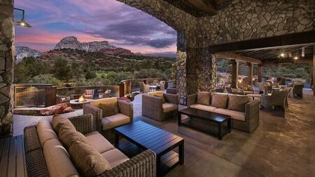 An outdoor seating area with stone walls, cushioned seating, and a view of the mountains. - Zen Retreat, Amazing Views, Minutes to Attractions (Sedona)