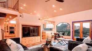 A spacious living area with a large TV, comfortable seating, and a dining area with a view. - Zen Retreat, Amazing Views, Minutes to Attractions (Sedona)