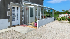 Une maison moderne dotée d’une grande porte vitrée, d’un toit en tuiles et d’une allée gravillonnée.