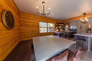 Una cocina moderna con paredes de madera, una isla central y un reloj grande.