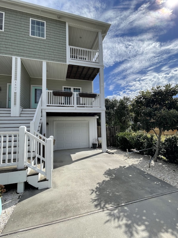 A two-story house with a garage, a covered porch, and a small balcony.