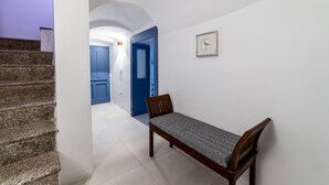 Ein Flur mit einer Bank, einer Treppe und einer Tür zu einem anderen Raum.
