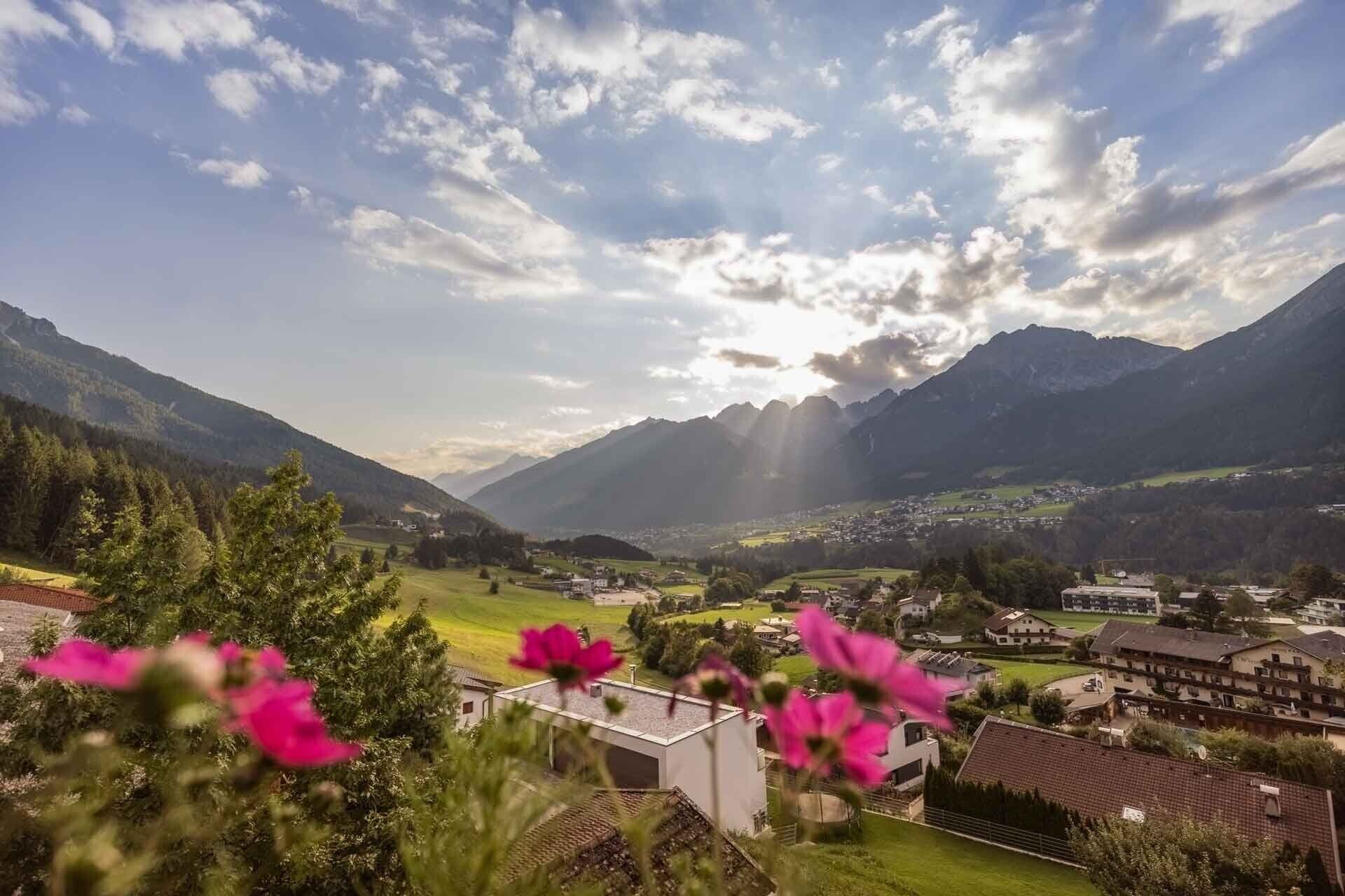 Un paysage montagneux avec un village, des maisons et un bâtiment doté d’un toit plat.
