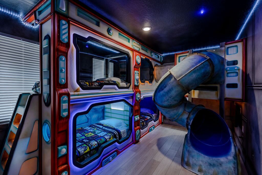 A room with bunk beds, a slide, and a window with blinds.