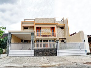 Et moderne hus i to etager med hegnet indgang, balkon og garage.