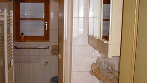 Un baño con lavamanos, espejo y ventana.