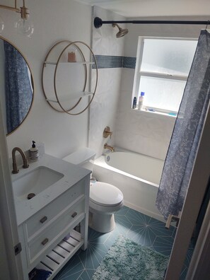 Combined shower/bathtub, towels, soap, toilet paper