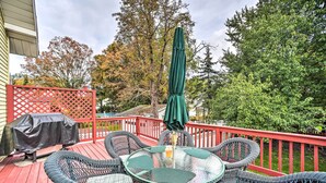 A covered outdoor patio with wicker furniture, a table, and an umbrella. - Pet-Friendly Latham Retreat ~ 7 Mi to Albany! (Latham)