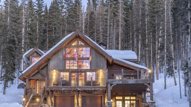 A log cabin with a large front porch, multiple windows, and a stone foundation. - Private Ski in/out Lodge! Hot Tub, 2 King En Suites, Stunning Views (Mountain Village)