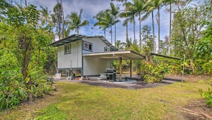 A two-story house with a covered patio and a small garden area. - Cozy Pahoa Hideaway Near Black-Sand Beaches! (Pahoa)