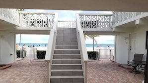 Un escalier menant à un balcon donnant sur une plage.