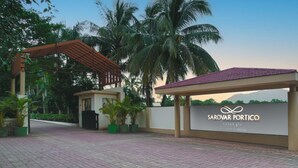 A modern hotel entrance with a sign reading "Sarovar Portico" and "Sasan Gir A Sarovar Hotel". - Sarovar Portico Gir (Mendarda)