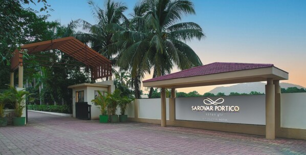 A modern hotel entrance with a sign reading "Sarovar Portico" and "Sasan Gir A Sarovar Hotel". - Sarovar Portico Gir (Mendarda)